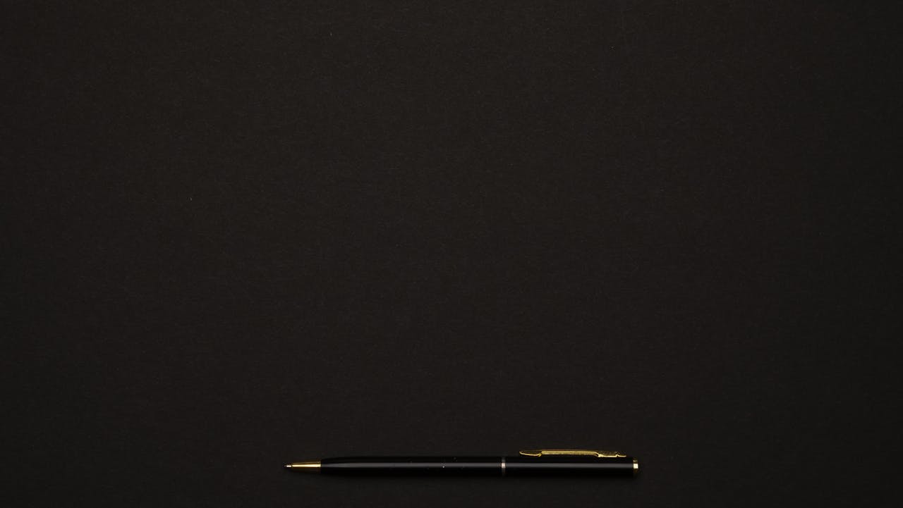 A sleek black pen placed on a minimalist dark background, perfect for professional presentations.